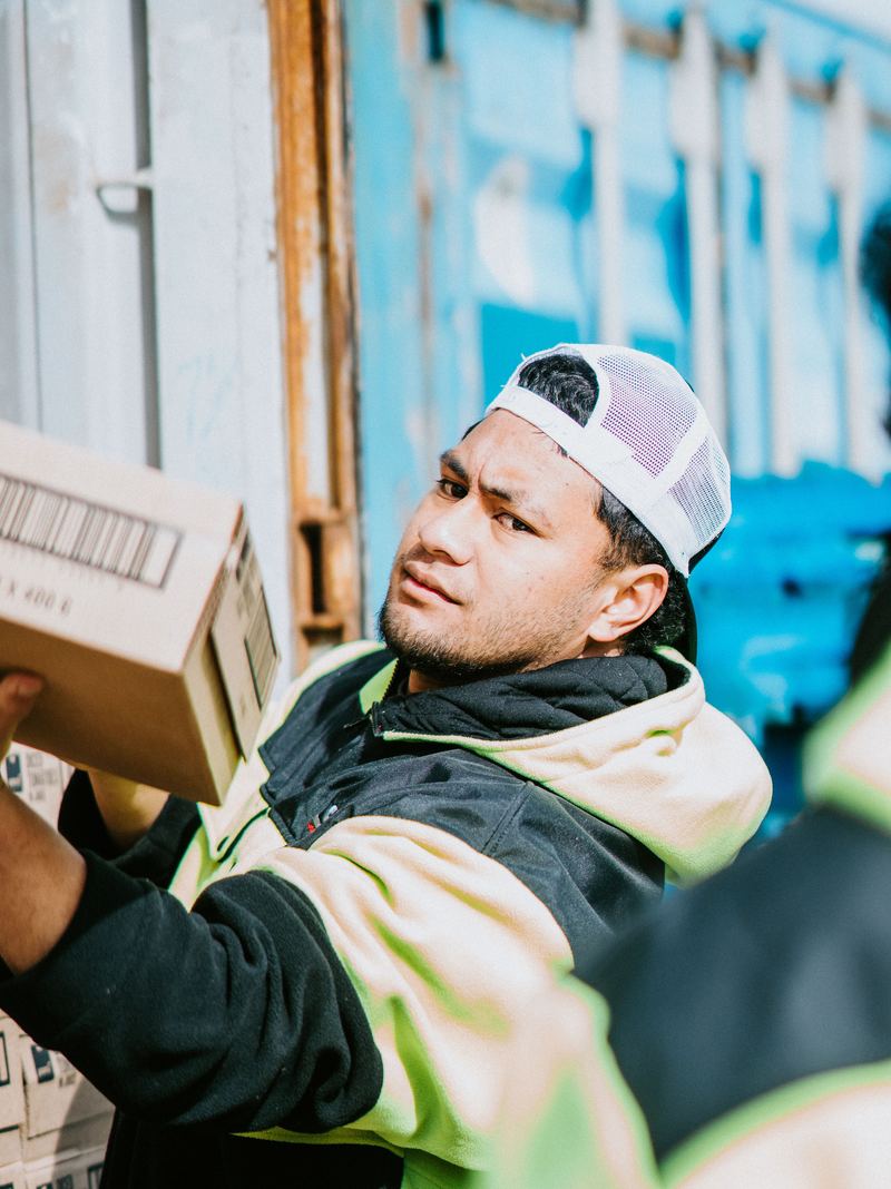 An LSL crew member passing cartons out of a container